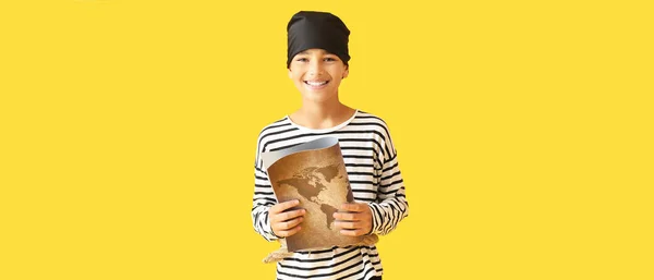 黄色の背景に宝の地図を持つ海賊の格好をした男の子 — ストック写真