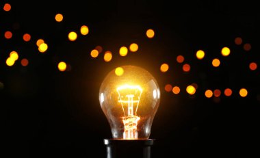 Koyu arkaplanda parlayan ampul, yakın plan