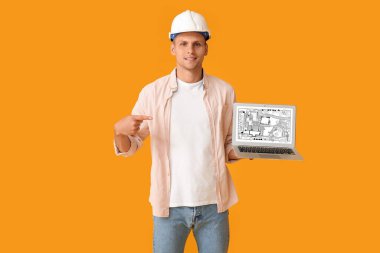 Turuncu arka planda dizüstü bilgisayarı olan erkek peyzaj tasarımcısı 