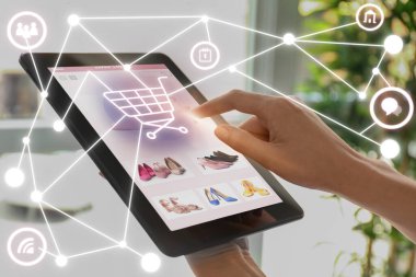 Tablet bilgisayarı olan kadın internetten ayakkabı alıyor, yakın plan.