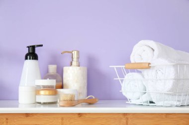 Leylak duvarının yanındaki masada banyo aksesuarları var.