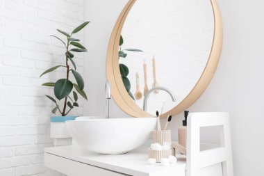 Banyo aksesuarları ve modern lavabo ışık duvarının yanında.