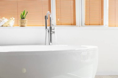 Banyo penceresinin yanındaki modern küvet.