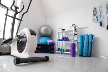 Raflar ve spor malzemeleriyle modern spor salonu.