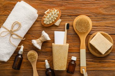 Ahşap arka planda banyo aksesuarları ve kozmetik ürünleri.