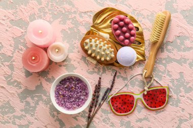 Arkaplanda yanan mumlar olan banyo aksesuarları.