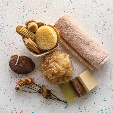 Hafif arka planda farklı masaj fırçaları olan banyo malzemeleri.