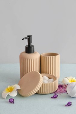 Açık arkaplanda çiçekli banyo aksesuarları