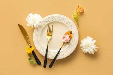 Bej arka planda güzel çiçekleri olan zarif bir masa.