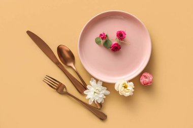 Bej arkaplanda güzel çiçek dekoru olan masa ayarı