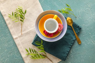 Fincanlı masa ayarları, çay kaşığı ve renk arkaplanlı çiçek dekoru