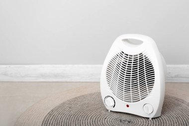Işık duvarının yanında elektrikli fan ısıtıcısı