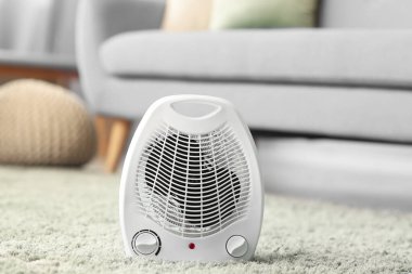 Electric fan heater on carpet in living room