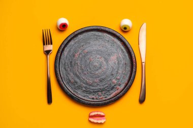 Cadılar Bayramı partisi için masa ayarları ve renkli arkaplanlı şekerler