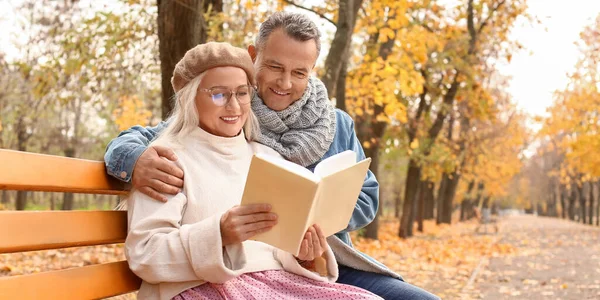 Happy Mature Couple Reading Book While Sitting Bench Autumn Park — Stock Photo, Image