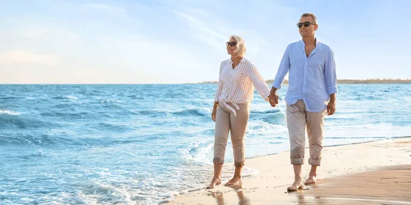 幸せな成熟したカップル海のビーチを歩く — ストック写真