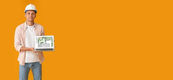 Male landscape designer with laptop on orange background with space for text