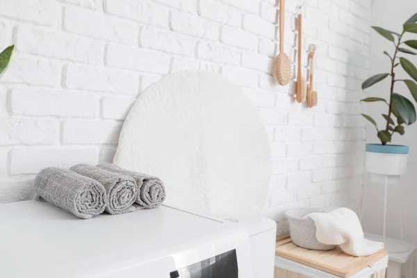 浴室白色砖墙附近洗衣机上的毛巾滚筒 — 图库照片