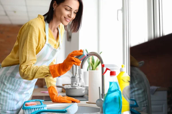 Młoda Kobieta Sprzątanie Kran Gąbką Kuchni — Zdjęcie stockowe