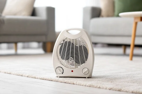 Electric fan heater on carpet in living room