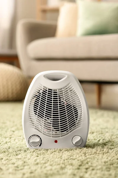 Electric fan heater on carpet in living room