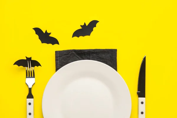 黄色の背景に紙で作られたコウモリとテーブルの設定 — ストック写真