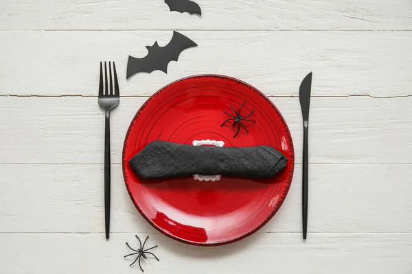 Table setting with Halloween decor on white wooden background