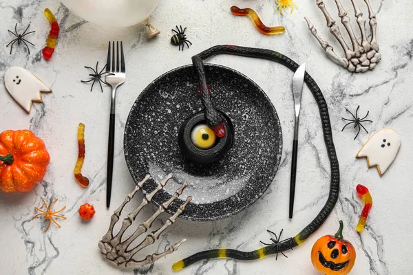 Thematic table setting for Halloween party on grunge background