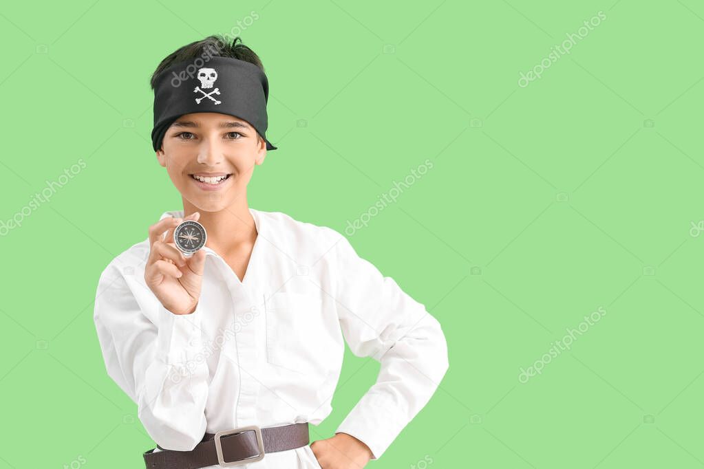 Little boy dressed as pirate with compass on green background