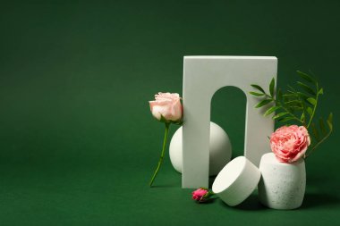Decorative plaster podiums and flowers on green background