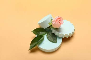 Plaster podiums and rose flower on color background