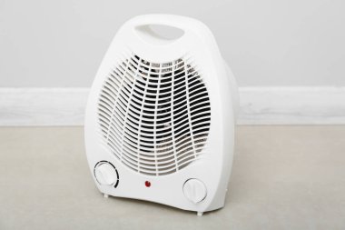 Işık duvarının yanında elektrikli fan ısıtıcısı