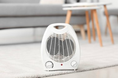 Electric fan heater on carpet in living room