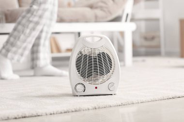 Electric fan heater on carpet in living room