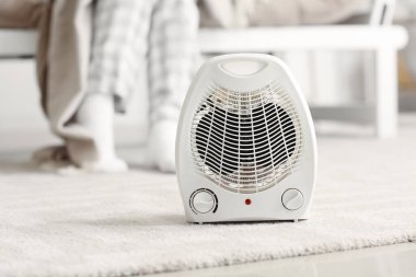 Electric fan heater on carpet in living room