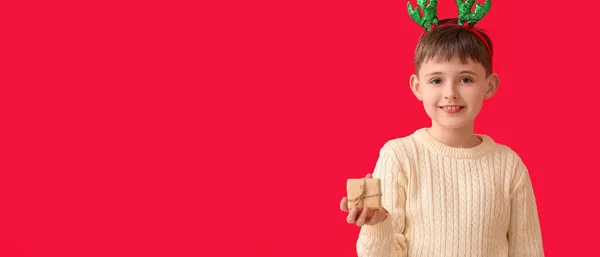 Niño Divertido Con Regalo Navidad Sobre Fondo Rojo Con Espacio —  Fotos de Stock