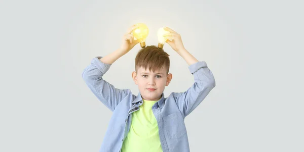 Cute Little Boy Glowing Light Bulbs Grey Background — Stock Photo, Image