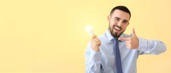 Empresário Apontando Para Lâmpada Brilhante Fundo Amarelo Conceito Ideia — Fotografia de Stock