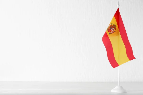 光の壁の近くのテーブルにスペインの国旗 — ストック写真