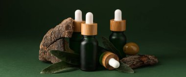 Koyu yeşil zemin üzerinde gerekli zeytinyağı şişeleri