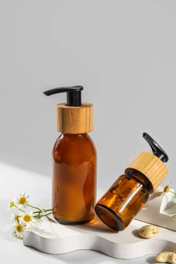 Beyaz arka planda doğal kozmetik ürünleri ve papatya çiçekleri.