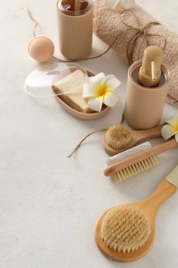 Hafif arka planda farklı masaj fırçaları olan banyo malzemeleri.