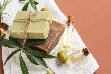 Renkli arka planda sabun çubukları ve zeytinyağı şişeleri, yakın plan