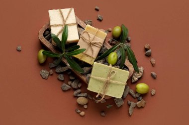 Renkli arkaplanda zeytin sabunları ve taşlar olan kompozisyon
