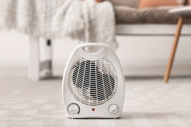 Electric fan heater on carpet in living room