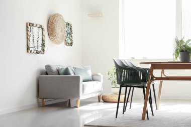 Masası, kanepesi ve çiçekleri olan hafif yemek odasının içinde.