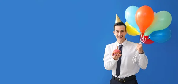 Happy businessman celebrating birthday on blue background with space for text