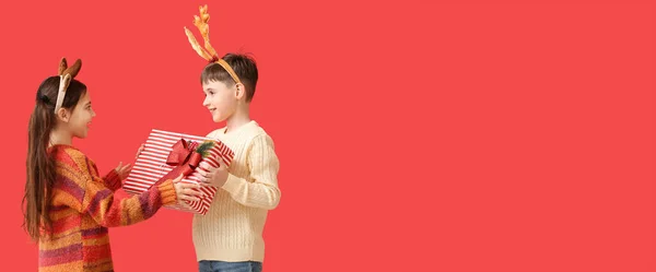 Niños Divertidos Con Cuernos Reno Regalo Navidad Sobre Fondo Rojo — Foto de Stock