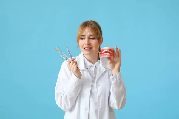 Dentista Feminino Assustado Com Modelo Mandíbula Plástico Ferramentas Fundo Azul — Fotografia de Stock