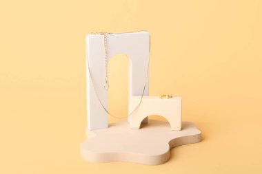 Composition with showcase pedestal and jewelry on color background